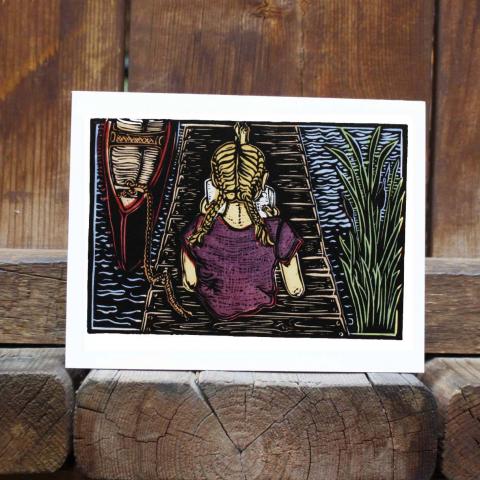 Card showing girl reading on a dock