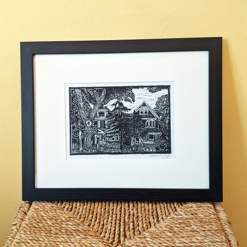 Framed print showing houses and trees