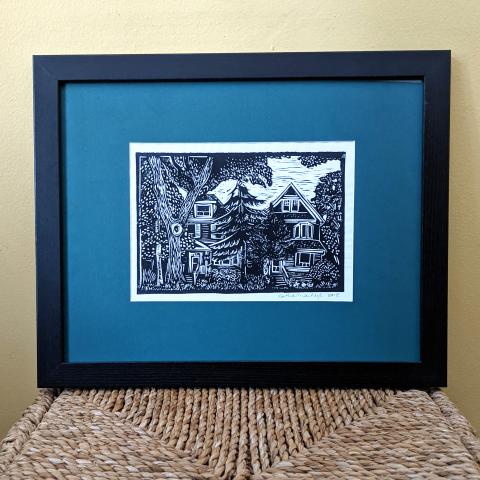 Framed print showing houses and trees