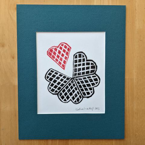 Matted print showing a waffle with one waffle heart separated out