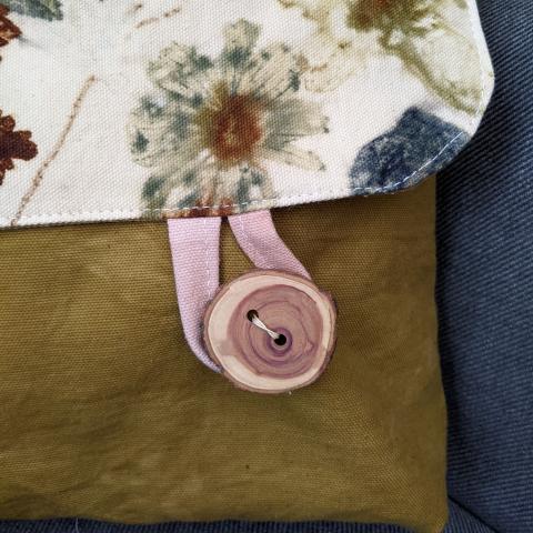 Detail of a wooden button on a plant dyed messenger bag