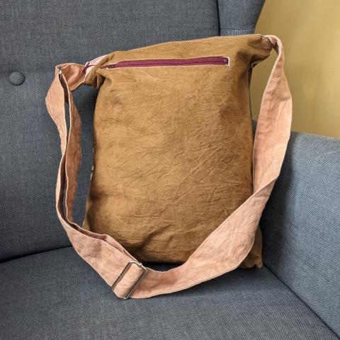 back of canvas bag with leaf prints and an adjustable strap