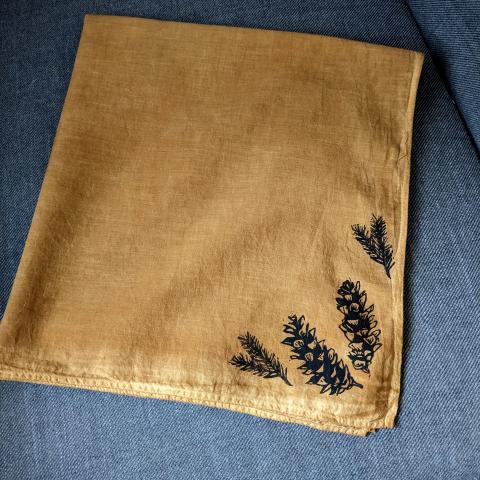 Rust coloured bandana with pine cones printed on