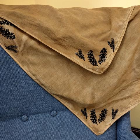 Rust coloured bandana with pine cones printed on