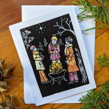 Card showing people visiting around a campfire in winter, with envelope