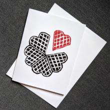 Greeting Card showing a black waffle with a red heart shaped segment separated from the rest